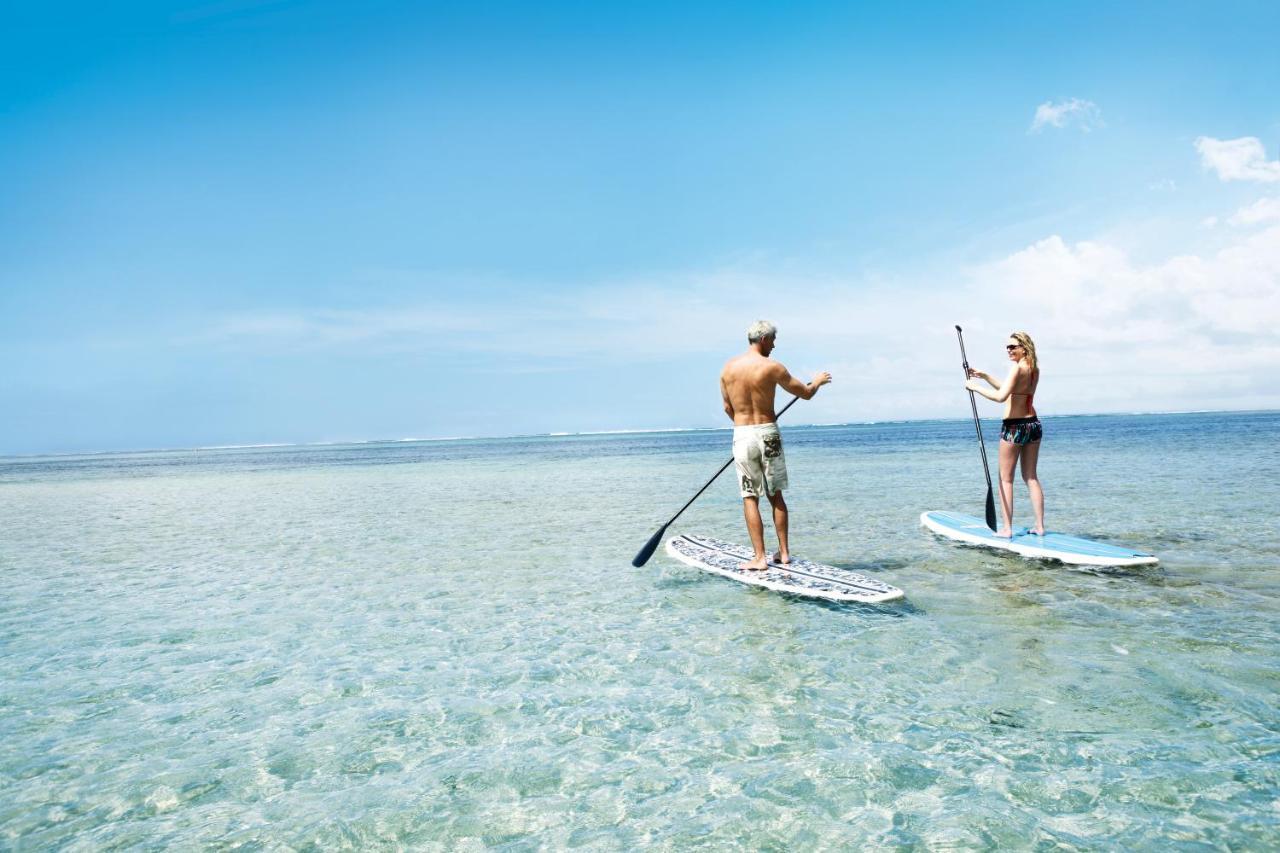 Heritage Le Telfair Golf&Wellness Resort Bel Ombre Exterior foto Stand-up paddle boarders on a lagoon