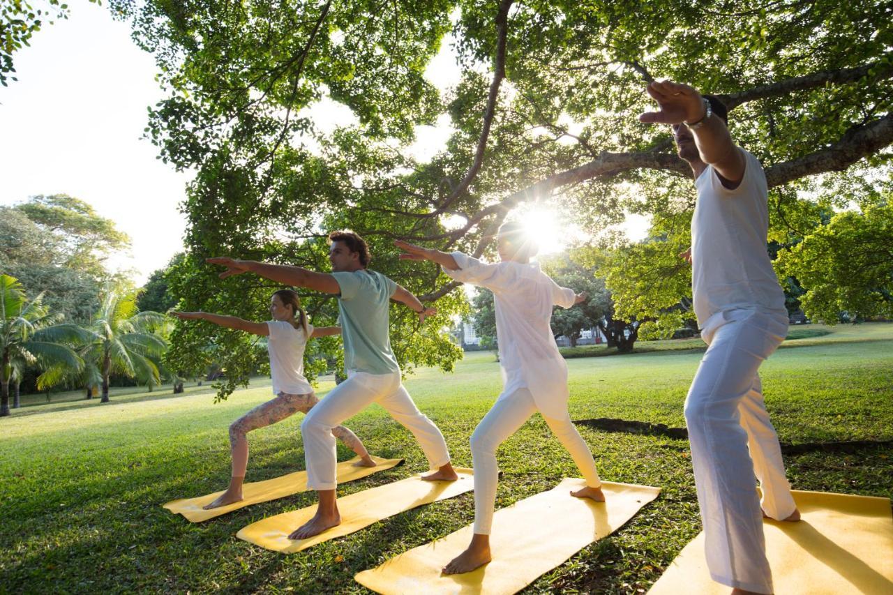 Heritage Le Telfair Golf&Wellness Resort Bel Ombre Exterior foto A group of people practicing yoga